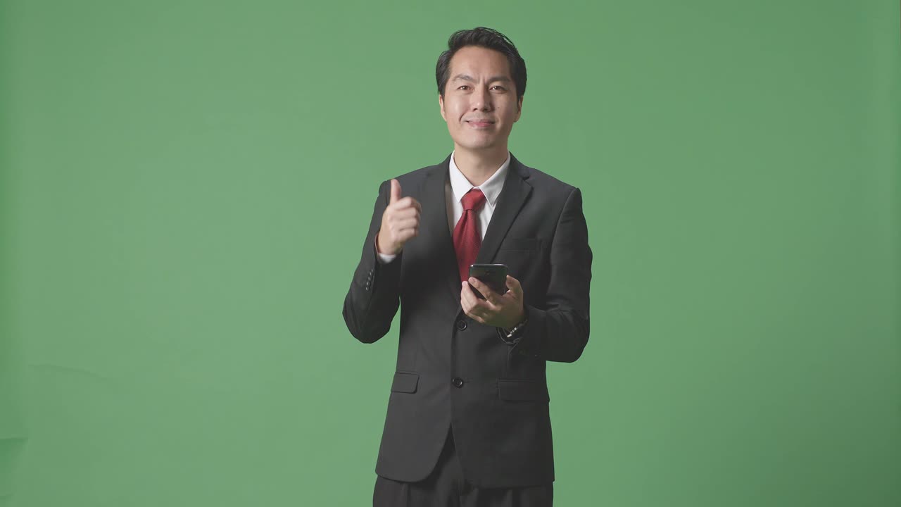 엄지손가락과 스마트폰을 들고 있는 사업가