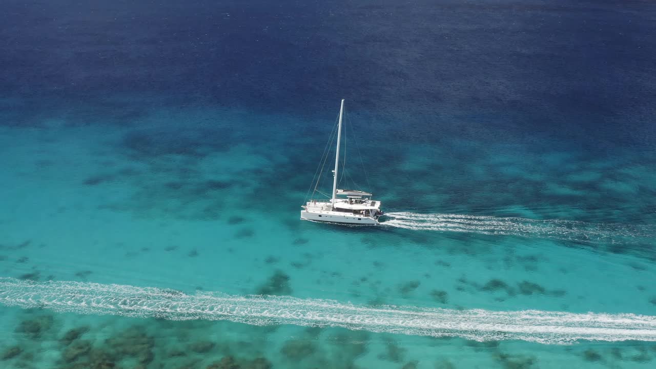 Aerial view of a catamaran sailing in the turquoise waters of the Caribbean