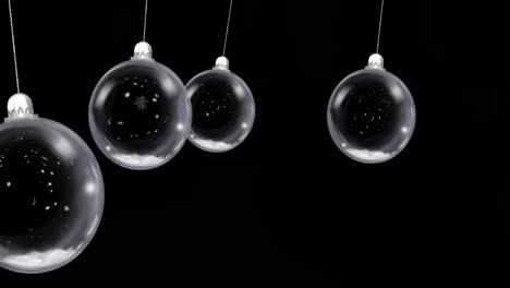 animation of christmas baubles dangling with snow falling on black background