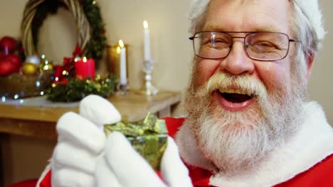 retrato de santa claus sosteniendo una caja de regalos