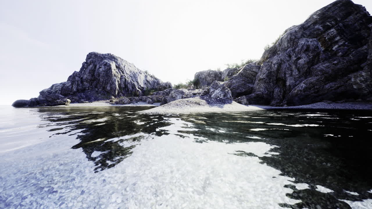 Calm shoreline with rocky formations and clear water during daylight hours