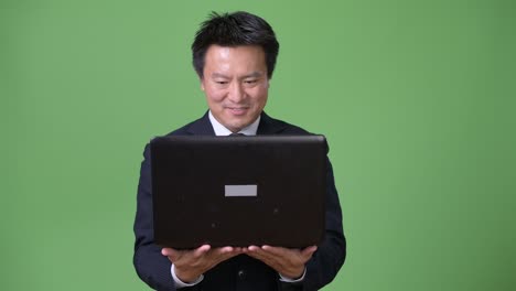 녹색 배경에 성숙한 일본 사업가