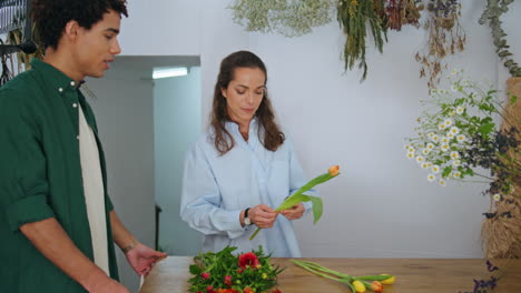 el cliente africano compra flores en la tienda de flores. la florista trabaja en el ramo de primavera.