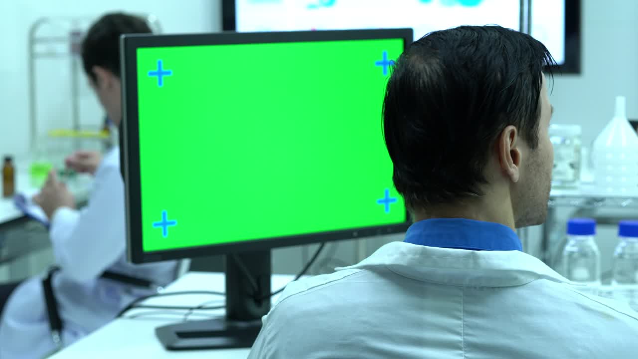 científico masculino hablando de trabajar en un laboratorio moderno o centro médico. monitor de fondo pantalla verde. concepto de ciencia, desarrollo de pruebas y industria de laboratorio.