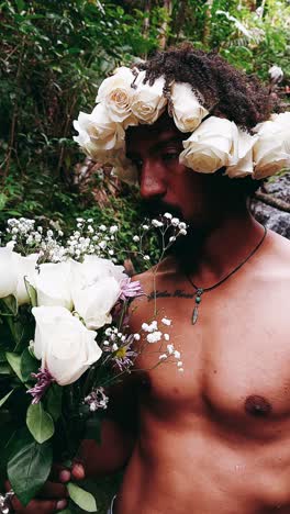 man in floral crown with bouquet of white roses