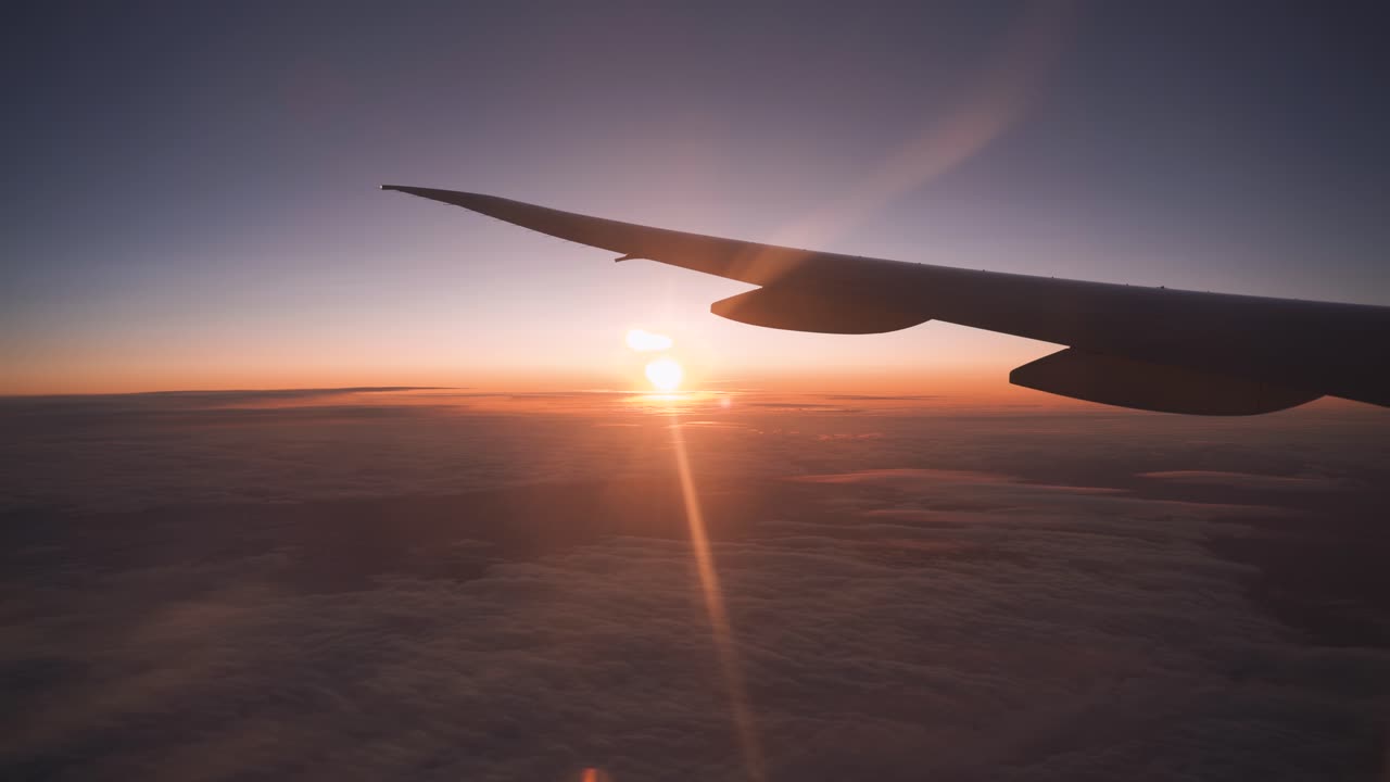 Airplane window view. Sun setting on horizon
