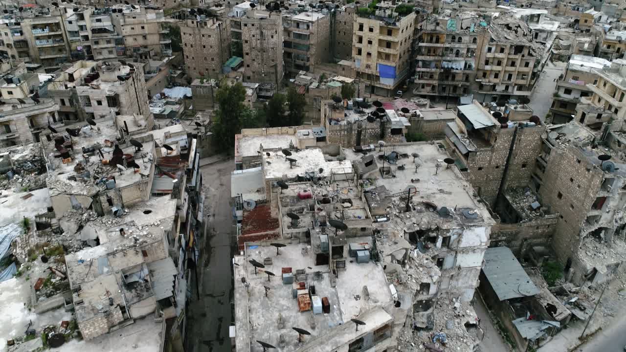 Aerial view over a syrian city. Some of the buildings are still in ruins after the civil war 10 years ago 4K