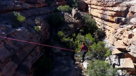 male highliner lying on a rope over rocky mountains 4k