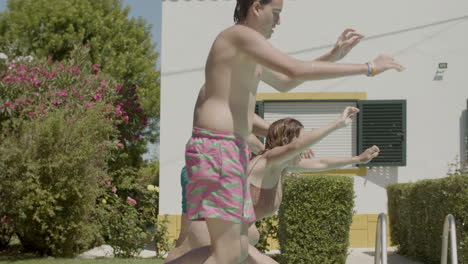 cheerful parents and kids running into swimming pools together