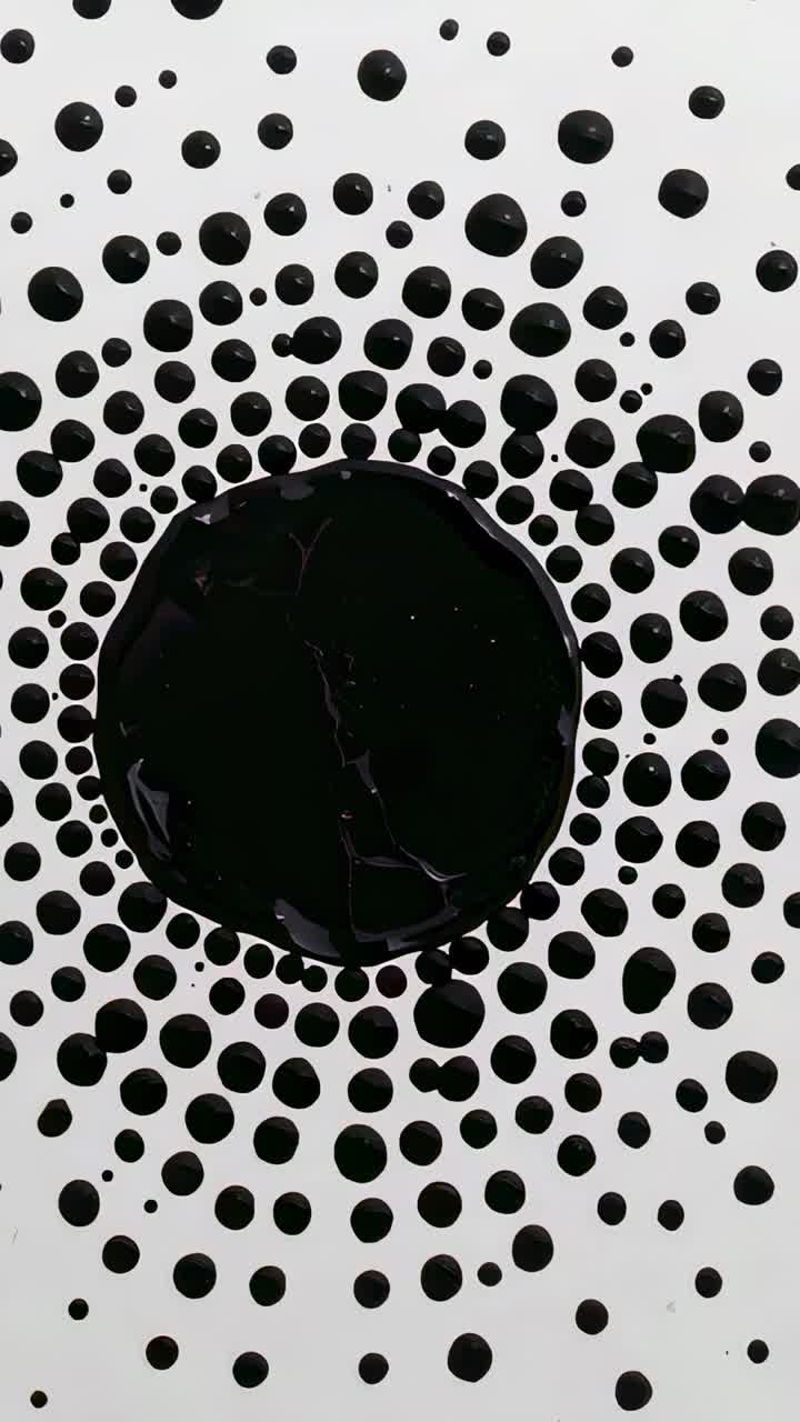 Vertical video: Starting top camera recording central black pool on white, showing radial droplets