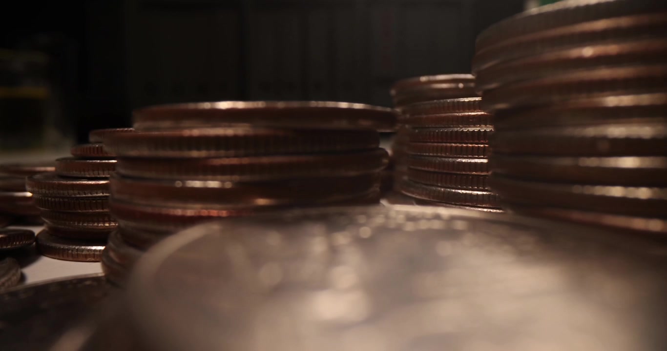 Copper coins stand in vertical stacks in dimly lit room