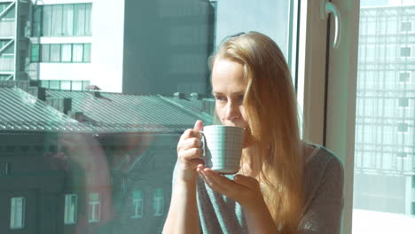 woman drinking morning tea by window