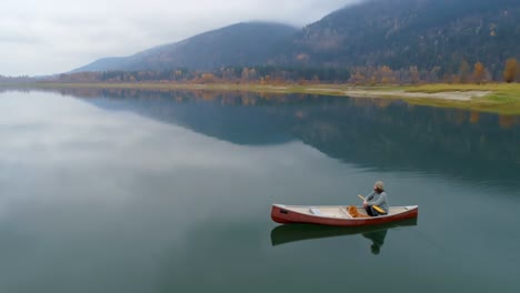 Hombre-Remando-En-Bote-Con-Su-Perro-En-Un-Lago-4k