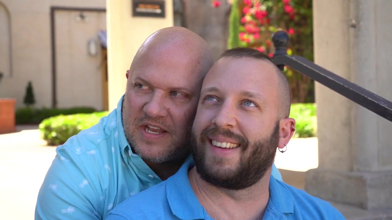 Coppia gay innamorata seduta e che si gode una giornata estiva.