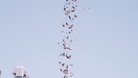 Corriente-De-Pequeñas-Piedras-Cayendo-Contra-El-Cielo-En-Una-Operación-De-Cantera.