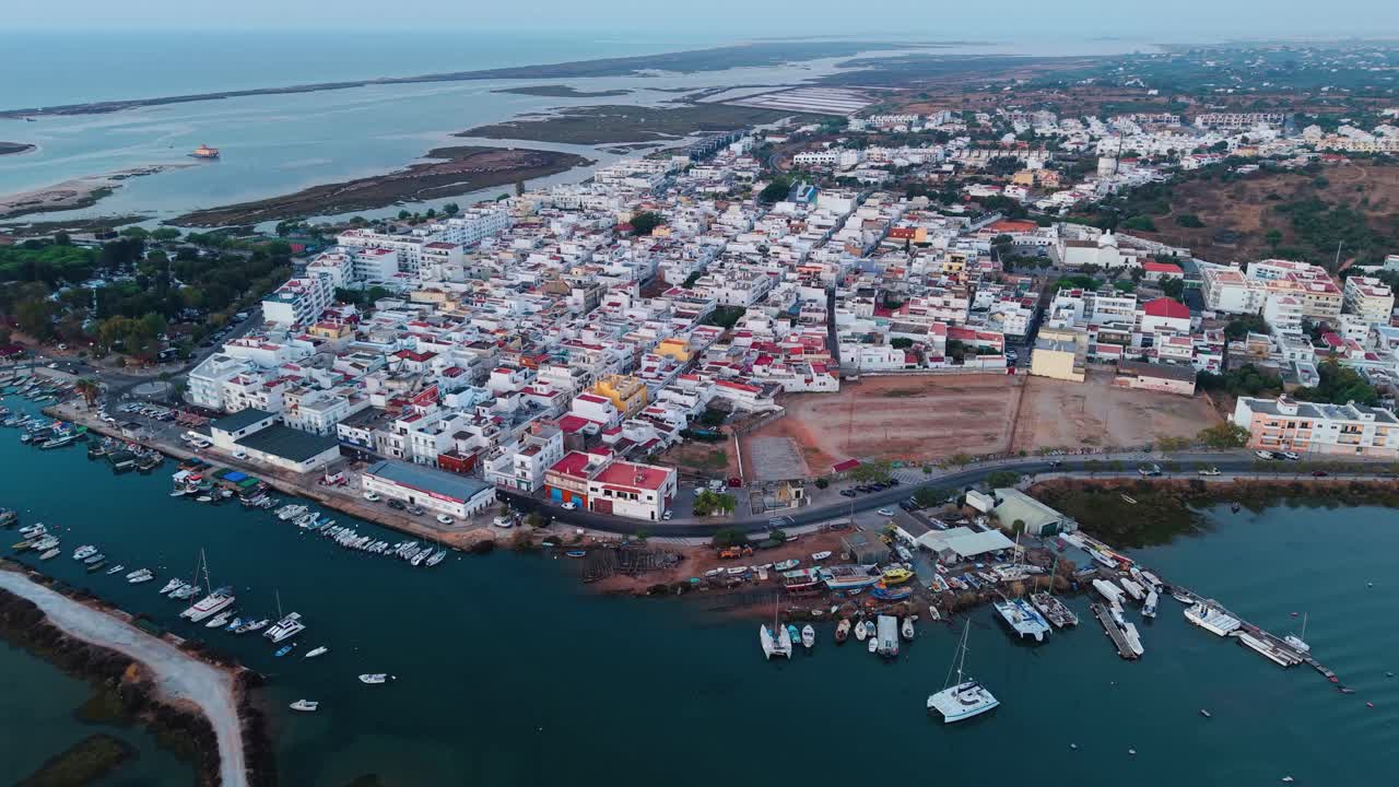Aerial shot above Fuseta fishing village at sunrise near Ria Formosa natural park in Algarve region, Portugal