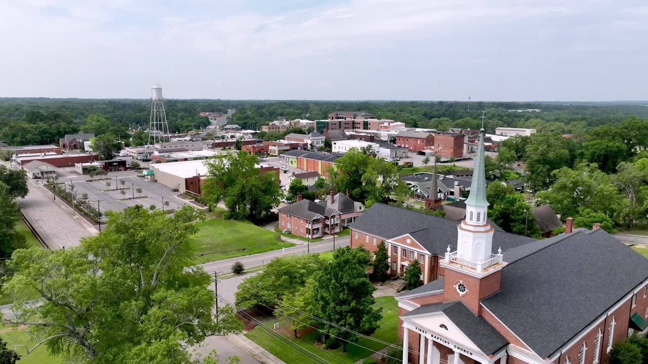 empujón lento aéreo sobre la iglesia con el horizonte de rockingham nc, carolina del norte en el fondo
