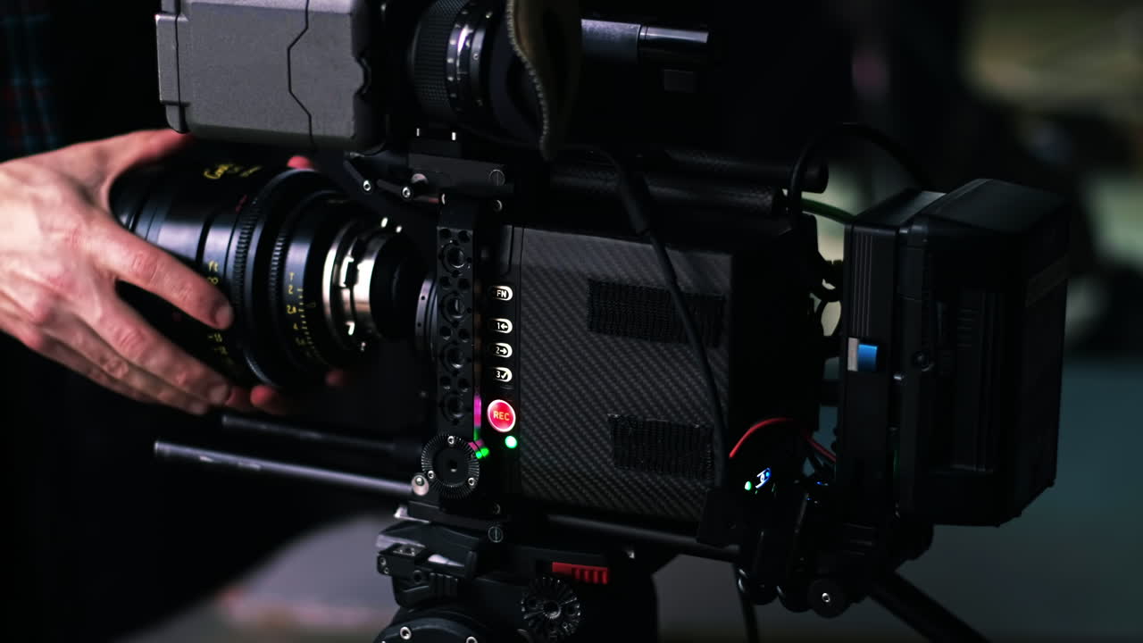 Man changing lens on a professional video camera on the movie set