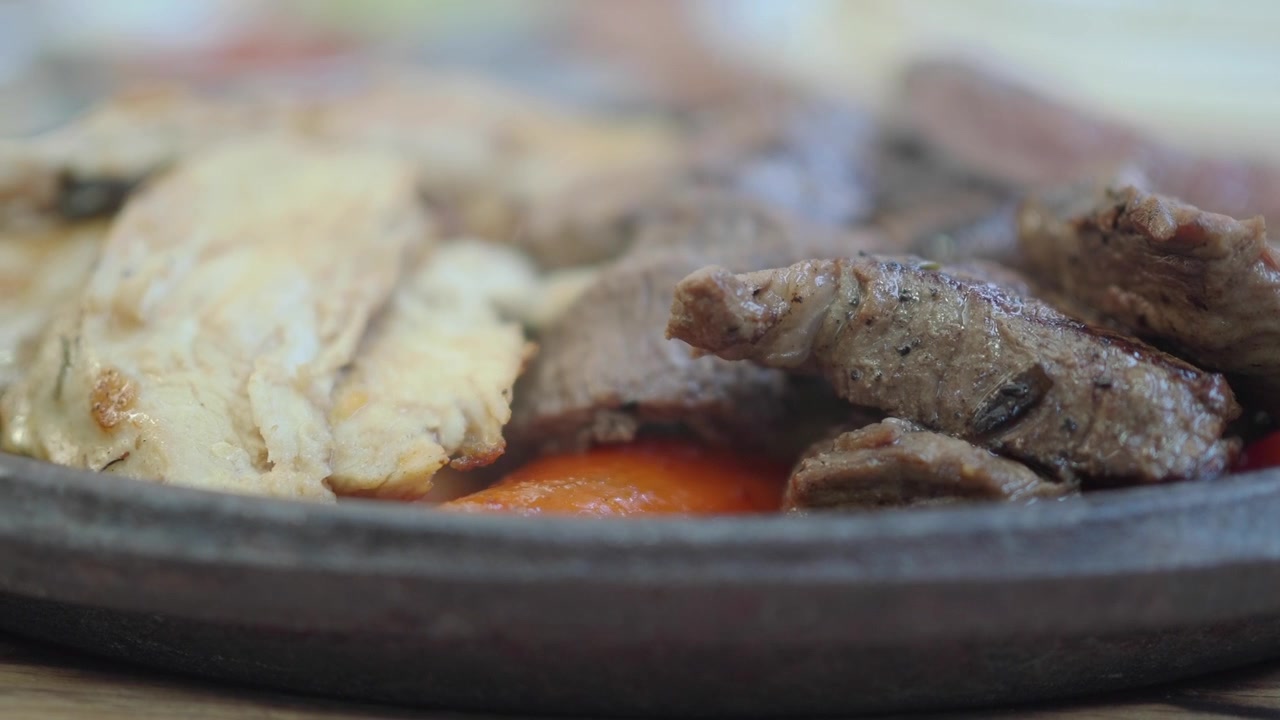Piatto di fajitas sfrigolanti con bistecca e pollo alla griglia