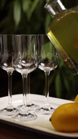 pouring liqueur into small glasses with bananas