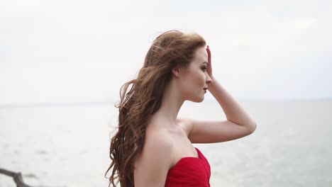 woman in red dress by the ocean