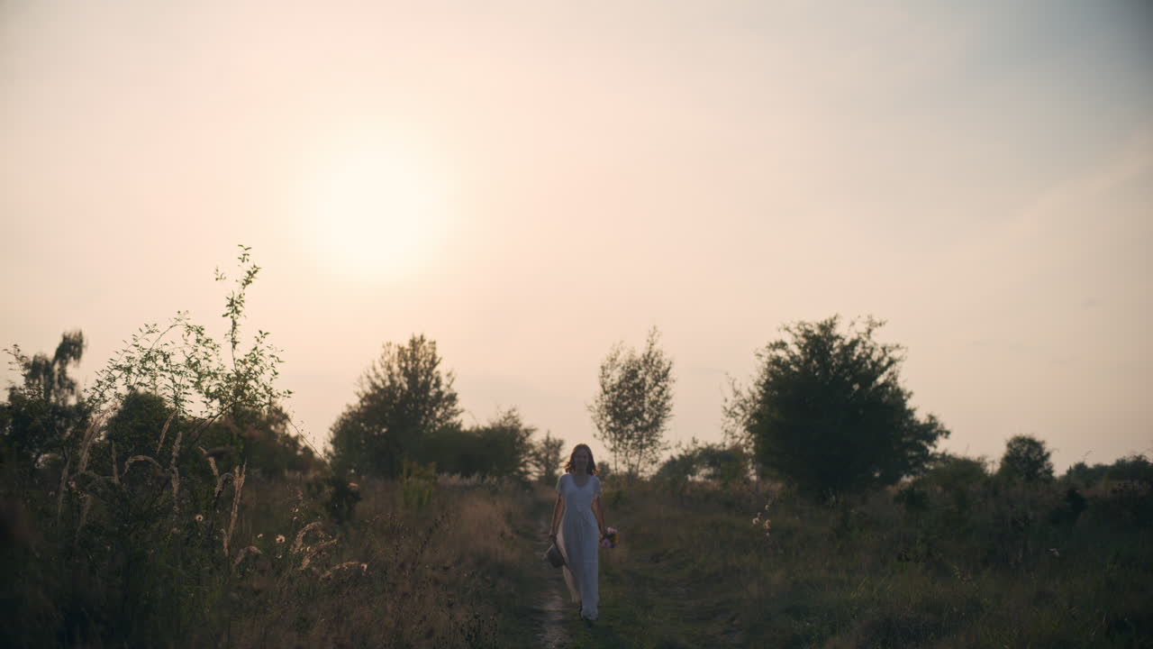 Smiling girl running through sunset meadow