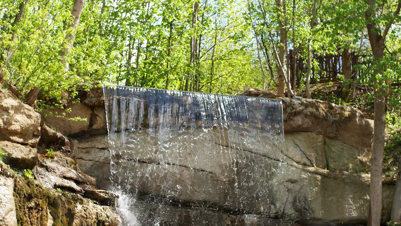 belle cascade d'une falaise dans la forêt. vidéo 4k de l'eau qui coule, le ruisseau qui coule entre les pierres. ruisseau dans la forêts