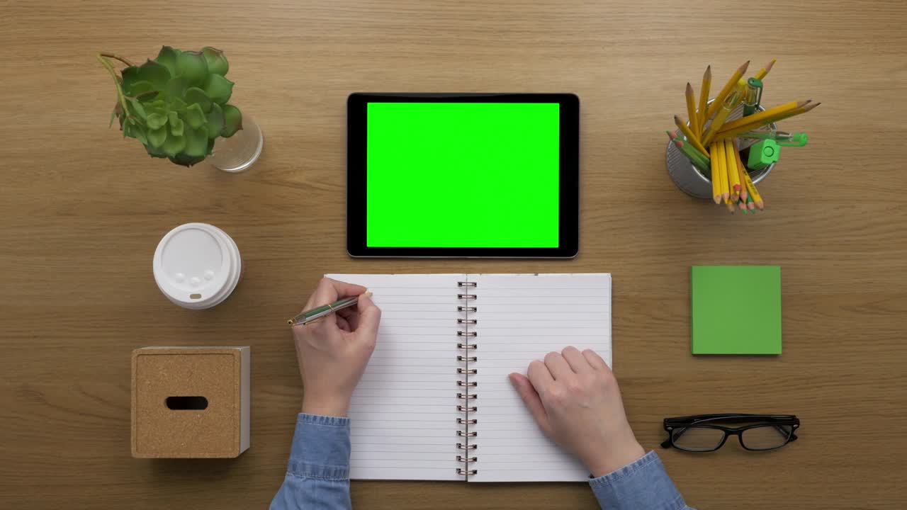 Overhead Top View Of woman Writing By Digital Tablet At Desk