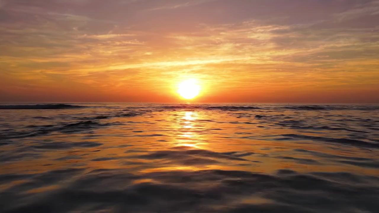 Betagende solnedgang over rolige havvande: En malerisk aftenscene, der fanger naturens skønhed, mens solen forsvinder i horisonten.