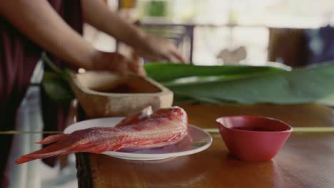 woman preparing fish in the kitchen