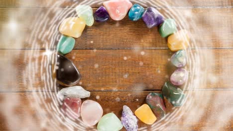 animation of blinking dots and stars over stones bracelet on wooden background