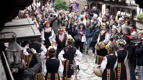 pretty bulgarian girls in colourful traditional dress perform easter time ritual dance in front of crowds
