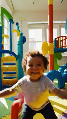 joyful toddler playing in a colorful indoor play area
