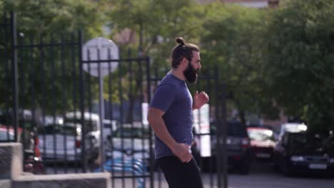 Fit-bearded-man-trains-HIIT-running-up-and-down-some-stairs-in-a-public-park