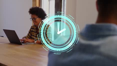 animation of clock moving fast over businesswoman using laptop in office