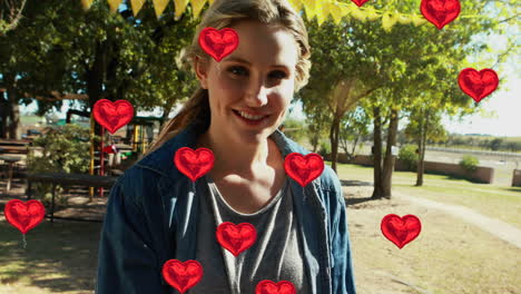 animación de corazones sobre feliz madre caucásica con niños en el parque