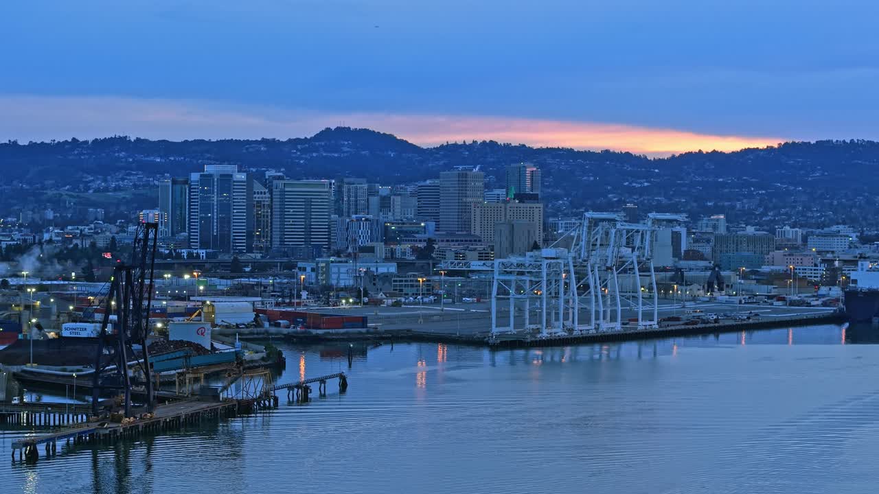 A locked down aerial view of the cranes and shipping operations along the Oakland Inner Harbor.