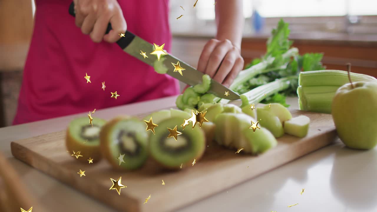 Woman slicing kiwi on kitchen cutting board, revealing celery and apple stars twinkling for cooking