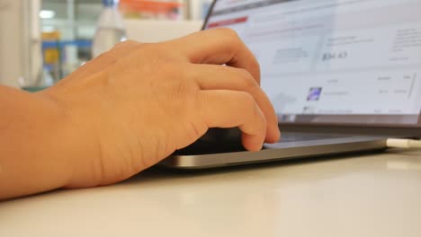 las manos de una mujer de negocios trabajando y escribiendo en una computadora portátil.