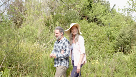 mature couple enjoying joyful walk in lush green garden, smiling together