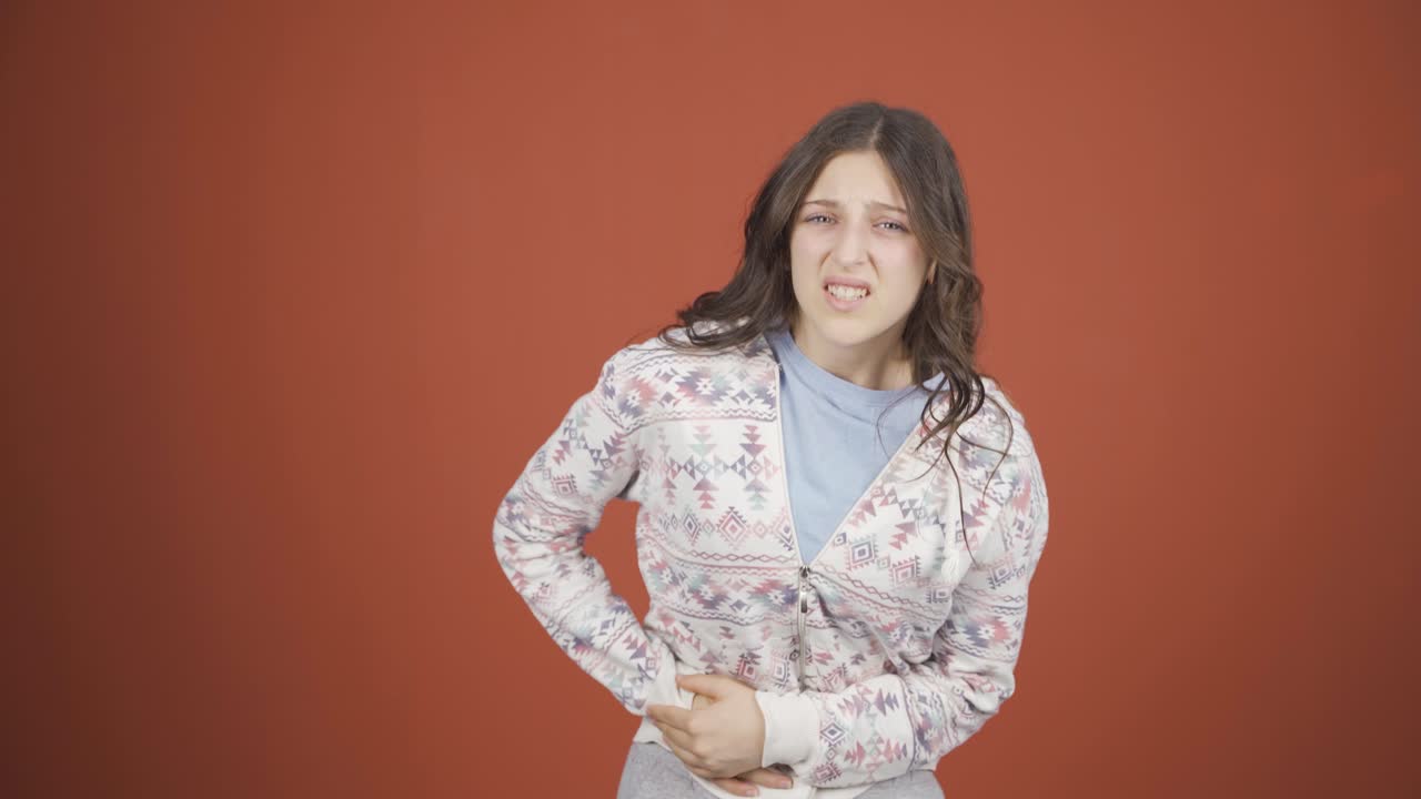 어린 여성이 복통을 겪고 있습니다.