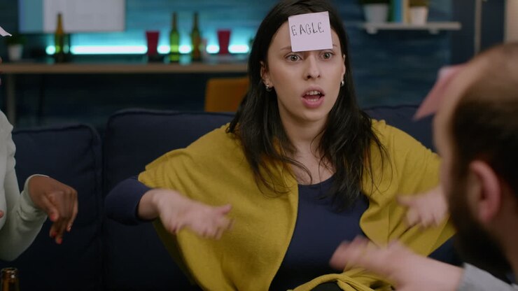 Divertenti amici multietnici con i post-it sulla fronte che si godono il gioco Indovina chi.