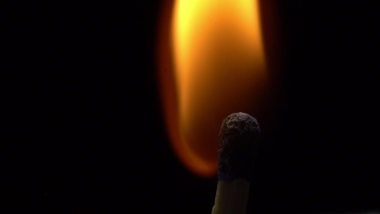 Slow motion of match head igniting, capturing spark and flame detail
