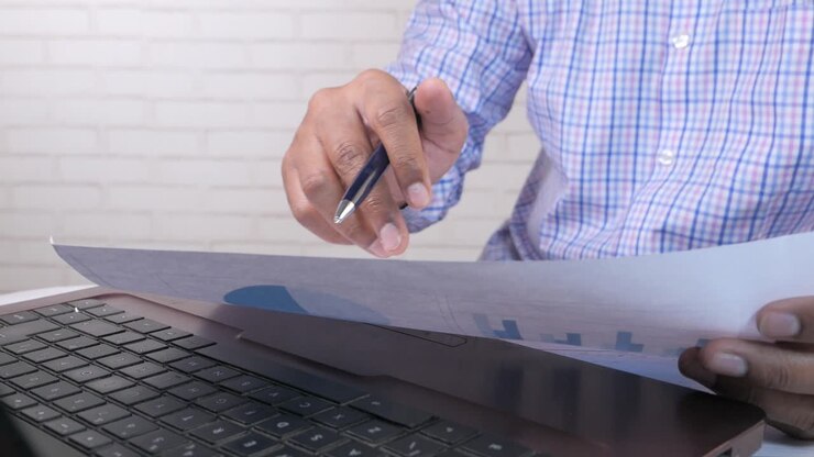 Persona che esamina documenti finanziari sul laptop