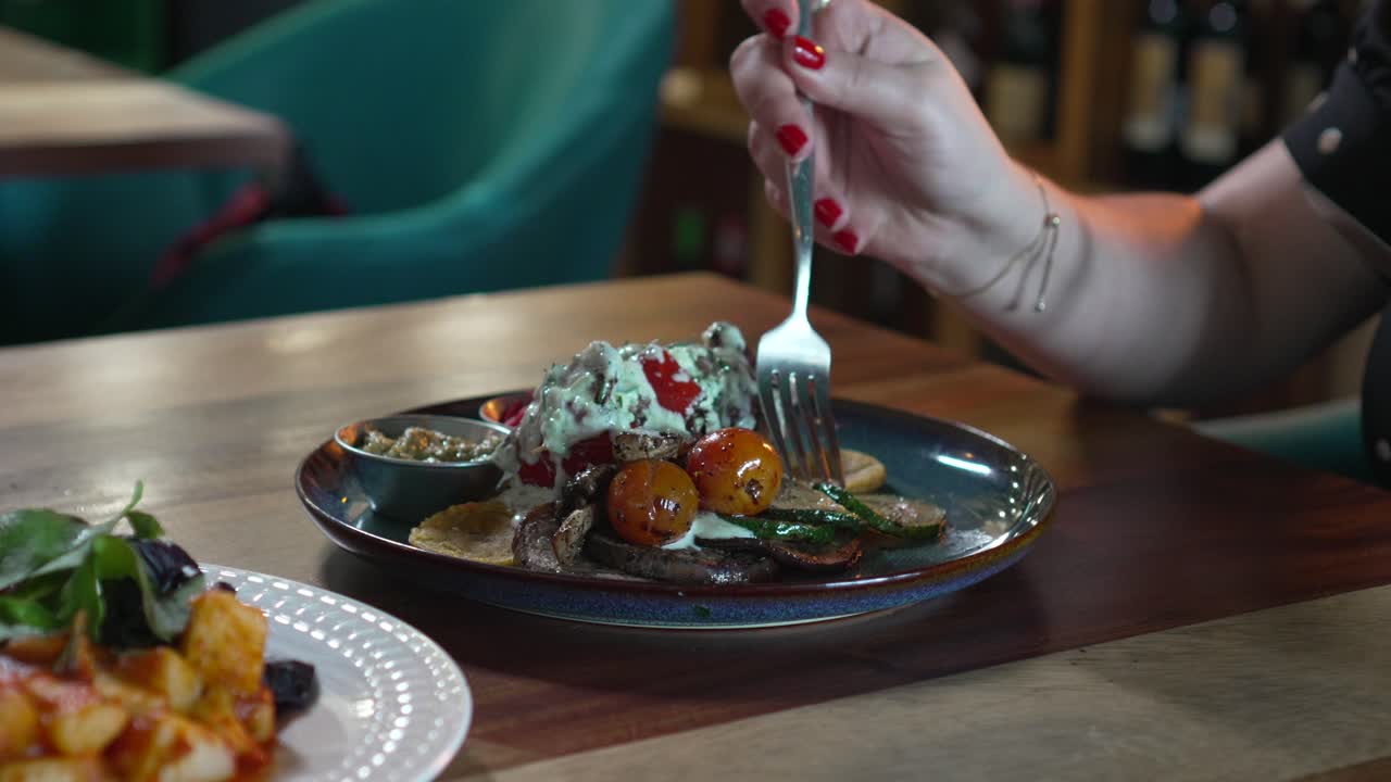 Business woman having lunch in elegant restaurant, woman's hands using fork to eat