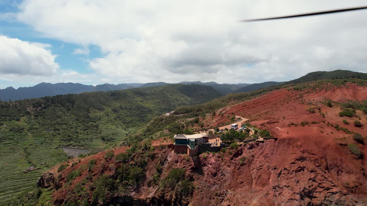 Rotating Drone View Reveals Mirador de Abrante, Red Rocky Formations and Backdropped by Lush Green Mountains, La Gomera