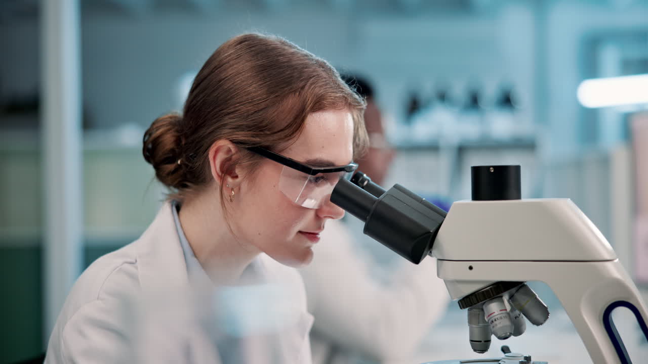 A scientist working with a microscope in a laboratory