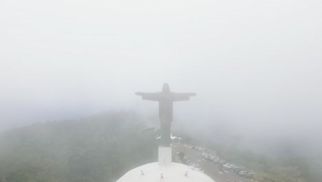 misty view of cristo redentor statue in puerto plata, surrounded by fog in dominican republic, aerial pullback of jesus christ sculpture