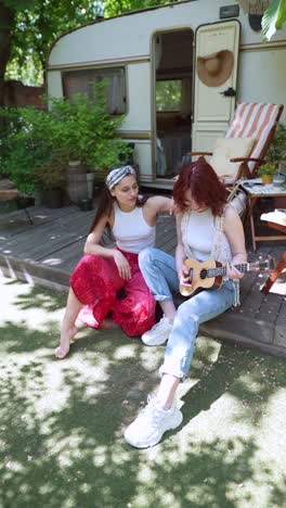 two women playing ukulele on a camping trip