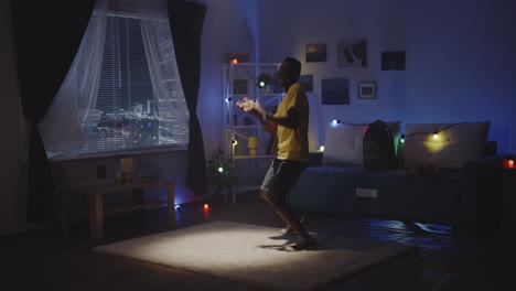 young man dancing in his room at night